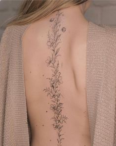 the back of a woman's neck with flowers on it