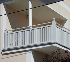 an apartment building with white balconies and railings on the balcony above it