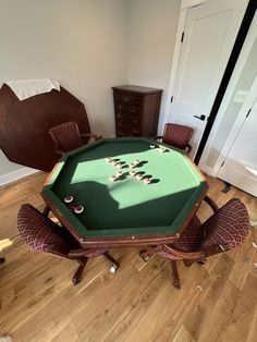 a pool table with chairs around it