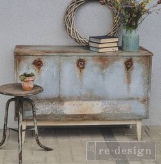 an old dresser with some plants on top and a potted plant next to it