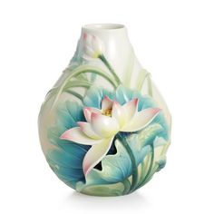 a white and blue vase with flowers painted on it