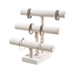 three pairs of hoop earrings are mounted on a white stand