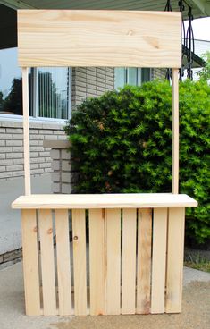 a wooden bench sitting in front of a bush