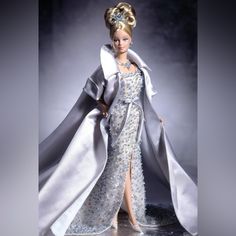 a barbie doll dressed in an evening gown with a long cape and high slit skirt