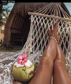 a person laying in a hammock with a coconut and flower decoration on it