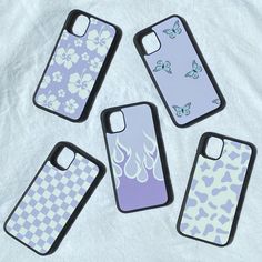 four cell phone cases sitting next to each other on a white sheet with butterfly designs