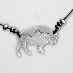 Stay free with this bison etched with the Tetons silhouette. Hand finished for rustic look and a acid-free etching process. Comes with rolo chain (16"-18") or monofilament cord (any length up to 30"), but customizable size available with varying beads depending on your cord. This style is offered in two finishes: Matte Silver and Antique Brass. Click here to learn more about our process. Details Length: 18” chain or 30” cord Adjustable Matte silver or antique brass Handmade in Montana Nickel, le Mountain Jewelry, Cuff Rings, Rolo Chain, Leather Cuffs, Ring Bracelet, Cable Chain, Men Necklace, Adjustable Rings, Earring Necklace