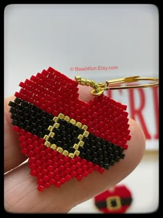 a hand holding a red and black beaded keychain