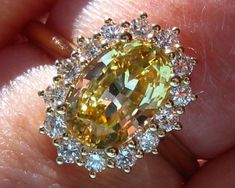 "A beautiful and delicate engagement ring featuring a sparkling oval yellow sapphire in a yellow gold diamond halo. The center stone is an oval sapphire, that weighs 2.53 carats and measures 9.2x6.2mm. It is a beautiful yellow color that looks like sunshine. This sapphire is basic heat only and comes from Sri Lanka (Ceylon). It is eye-clean and has beautiful sparkle, be sure to check out the video. Excellent choice for an engagement ring! The sapphire is set in a 14K yellow gold ring with diamon Yellow Oval Halo Jewelry, Yellow Sapphire Engagement Ring, Yellow Sapphire Ring Engagement, Delicate Engagement Ring, Engagement Ring Mountings, Diamond Halo Engagement Ring, Rose Gold Engagement, Engagement Rings Oval, Halo Diamond Engagement Ring