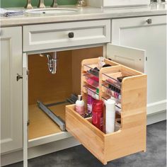 an open drawer in a kitchen next to a sink