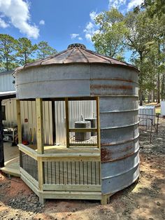 a round metal structure sitting on top of a dirt field