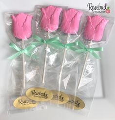 four pink and green lollipops wrapped in cellophane