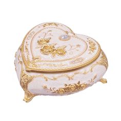 a white and gold heart shaped box with flowers on the lid, sitting on a white surface