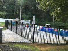 a fenced in swimming pool with an umbrella over it