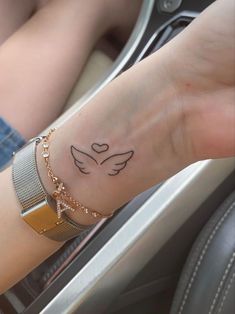 a woman's arm with a small dove tattoo on her left wrist and the word love written in black ink