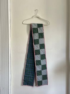 a green and white checkered tie hanging on a wall