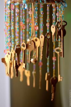 several keys are hanging from a chandelier with beaded strands and beads around them