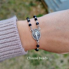 "This rosary bracelet features saint medal of your choice in the middle as centerpiece, and beautiful 4mmcrystal pearls in color of your choice on the side. Design your own bracelet and we will make it for you: Select saint medal and pearls color for your bracelet, and it will be made just for you. -SEE PHOTOS ABOVE- Handwoven in Medjugorje. Medals made in Italy. This unique bracelet comes on cording with a sliding slipknot for an easy fit. 9.5\"(24cm) when fully opened. This unique Rosary brace Prayer Message, Catholic Bracelet, Toddler Bracelet, Angel Bracelet, Side Design, Rosary Bracelet, Saints Medals, Protection Bracelet, Catholic Gifts