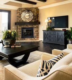 a living room filled with furniture and a flat screen tv mounted on the wall above a fireplace