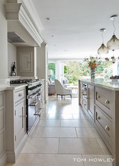 a large kitchen with an oven, stove and chairs inside of it's center island