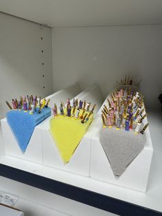 three display cases with pens and pencils in them