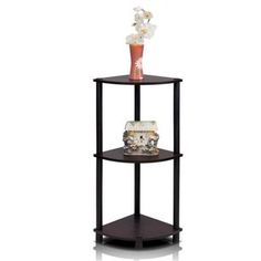 a black corner shelf with a vase and cake on the top, against a white background