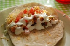 a tortilla on a plate topped with meat and vegetables