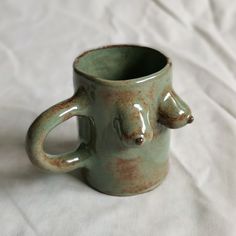 a ceramic cup with two bears on the inside and one in the middle, sitting on a white sheet