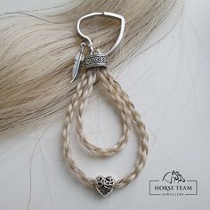 a pair of hair clips on top of a furry animal's tail with an arrow charm hanging from it