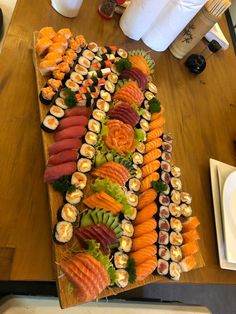 an assortment of sushi on a wooden platter