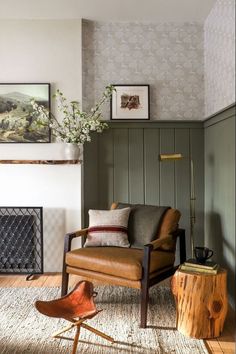 a living room with a chair, fireplace and pictures hanging on the wall above it