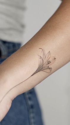 a woman's arm with a flower tattoo on the left side of her arm