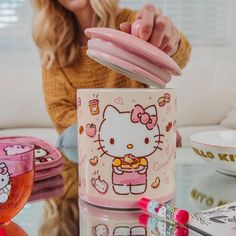 a hello kitty coffee mug sitting on top of a table