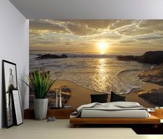 a bedroom scene with the sun setting over the ocean and beach wall mural on the wall