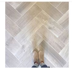 a person standing on top of a wooden floor next to a tile flooring pattern