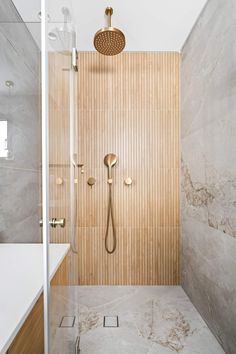 a bathroom with a shower head and wooden paneling on the wall next to it