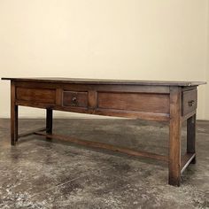 an old wooden table with two drawers on it