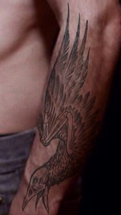 a man's arm with a bird tattoo on the left side of his body