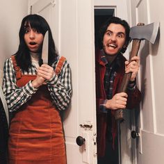 two people standing in front of a door, one holding an ax and the other holding a hammer