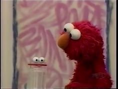 the sesame street character is next to an empty glass bottle with googly eyes on it