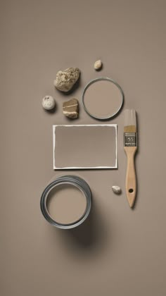 various items are arranged on a gray surface including a paintbrush, brush and paper