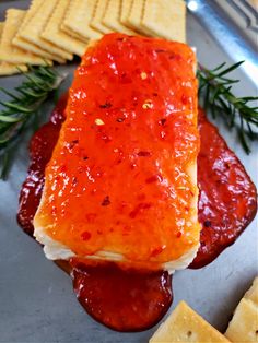 a plate with crackers, cheese and ketchup on it