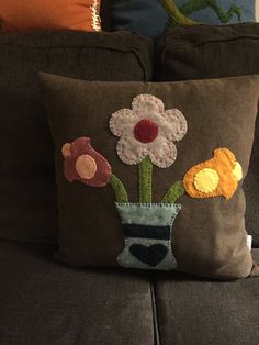 a pillow with flowers in a vase on a couch