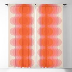 an orange and pink abstract design sheer curtain with circles in the center, on a white wall