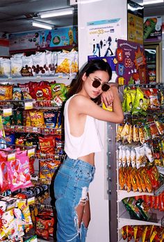 a woman standing in front of a store filled with candy