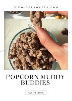 a hand holding a spoon over a bowl of popcorn muddy buddies