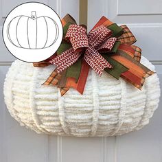 a white pumpkin shaped basket hanging from the front door with a ribbon bow on it