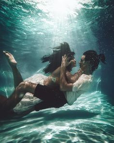 a man and woman are underwater in the water