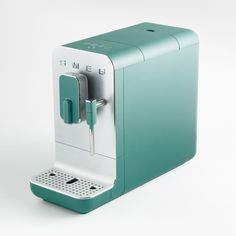 a green and white coffee machine sitting on top of a table