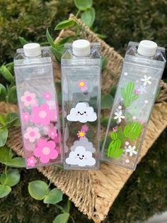 three water bottles with flowers and clouds on them